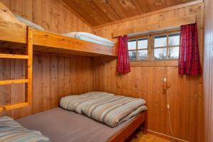 ein Schlafzimmer mit Etagenbetten in einer Holzhütte in der Unterkunft Besseggen Fjellpark AS in Maurvangen