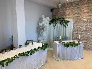 two tables in a room with plants and balloons at Apart-Hotel Rheinischer Hof Dormagen in Dormagen