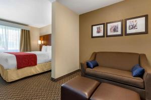 a hotel room with a bed and a couch at Comfort Suites Phoenix Airport in Tempe