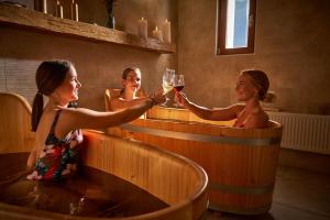 three women in a hot tub holding glasses of wine at Hotel Ryzlink in Mikulov