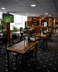 a restaurant with wooden tables and chairs and a bar at OX Hotel Manchester in Manchester