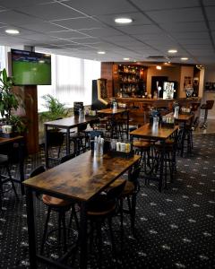 a restaurant with wooden tables and chairs and a bar at Milton Manchester Hotel in Manchester
