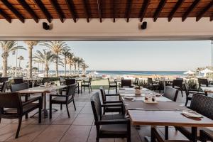 a restaurant with tables and chairs and the beach at Golden Star Beach in Protaras
