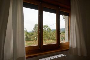 ein Fenster im Bad mit Blick auf die Bäume in der Unterkunft Casa Peña Guardavistas in Derroñadas