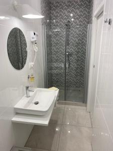 une salle de bain blanche avec un lavabo et une douche dans l'établissement Cztery Sosny - noclegi Zasieki, à Zasieki 20 autres photos