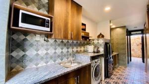 a kitchen with a sink and a microwave at Lotus Beach House in Phan Thiet