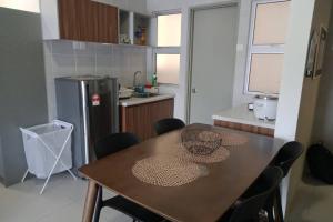 una cucina con tavolo, sedie e frigorifero di LOVE LODGE BRINCHANG, CAMERON HIGHLANDS a Tanah Rata