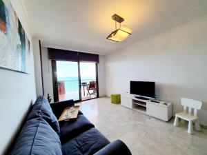 salon z kanapą i telewizorem w obiekcie Carvajal Seaviews w mieście Benalmádena
