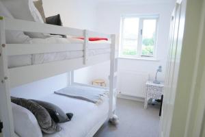 1 dormitorio con 2 literas y ventana en The Croft a lovely town house in the centre of Holt with free PARKING for two cars, en Holt