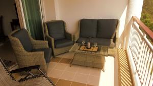 a balcony with two chairs and a table at Seaview Condo B63 in Mae Pim