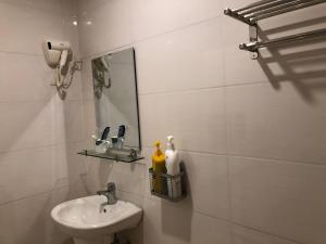 a white bathroom with a sink and a mirror at Nàng Hương Motel in Hanoi