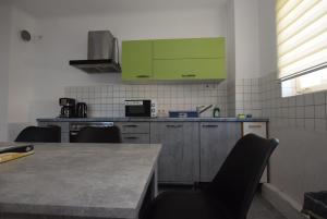 a kitchen with green cabinets and a table and chairs at Apartment Nürtingen Zentrum in Nürtingen
