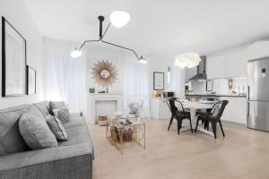 ein Wohnzimmer mit einem Sofa und einem Tisch mit Stühlen in der Unterkunft MintyStay - Luca de Tena in Madrid