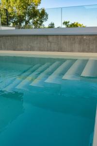 a swimming pool with blue water at Live Hotels Bordeaux Lac in Bordeaux