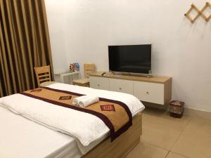 a hotel room with a bed and a flat screen tv at Nàng Hương Motel in Hanoi