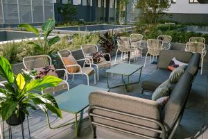 a patio with couches and tables and chairs at Live Hotels Bordeaux Lac in Bordeaux