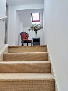 a set of stairs with a chair and a vase of flowers at Heron's View in Ruthin