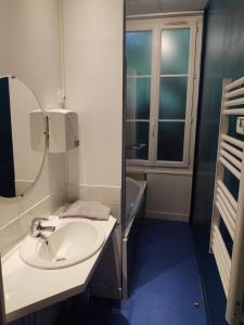 ein Bad mit einem Waschbecken und einem Spiegel in der Unterkunft Manoir de Bolbec in Bolbec