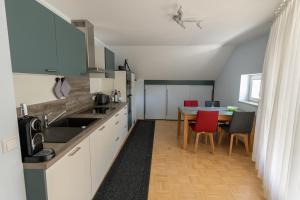 una cucina con lavandino e tavolo con sedie di Stadthaus Seeblick E75 a Friedrichshafen
