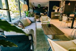 a living room with couches and a wooden table at Live Hotels Bordeaux Lac in Bordeaux