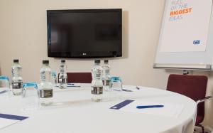 a table with bottles of water on it with a tv at Holiday Inn Express Tamworth by IHG in Tamworth