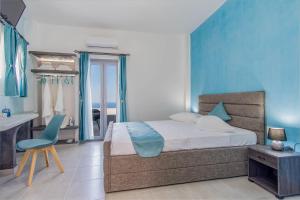 a bedroom with a bed and a desk and a chair at N RENIERIS Apartments in Firostefani