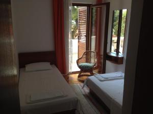 Cette chambre dispose de deux lits, d'une chaise et d'une fenêtre. dans l'établissement B&B Pansion Jure Matijević, à Sveta Nedelja