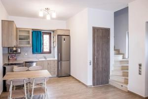 a kitchen with a table and chairs in a room at Amousso Beach Villas in Marantochori
