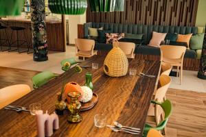 a dining room with a wooden table and chairs at Live Hotels Bordeaux Lac in Bordeaux