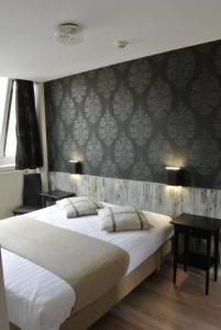 1 dormitorio con 1 cama grande y escritorio en Hotel Tropicana, en Blankenberge