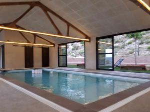 a swimming pool in a house with windows at Casa Rural els Esclopets in Sanahuja