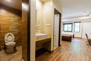 a bathroom with a toilet and a sink at Namtok Sarika Resotel in Nakhon Nayok