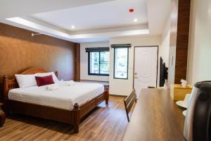 a bedroom with a bed and a window and a door at Namtok Sarika Resotel in Nakhon Nayok