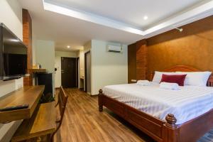 a bedroom with a bed and a flat screen tv at Namtok Sarika Resotel in Nakhon Nayok