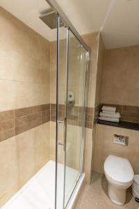 a bathroom with a toilet and a shower stall at Hogs Back Hotel & Spa in Farnham