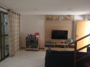 a living room with a television and a couch at Village Reserva das Ilhas - Itacimirim in Itacimirim