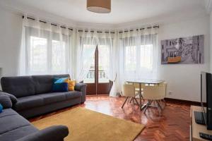 un soggiorno con divano e tavolo di Green Corner House a Lisbona