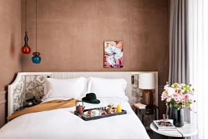 a bedroom with a bed, a dresser, and a painting on the at Sofitel Le Scribe Paris Opera in Paris