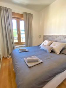 - une chambre avec un grand lit et des serviettes dans l'établissement Vila Elsa I S32, à Zlatibor