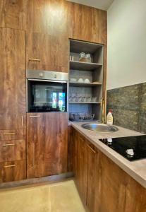 - une cuisine avec des placards en bois et un évier dans l'établissement Vila Elsa I S32, à Zlatibor