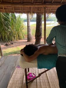 a woman is laying on a chair under a umbrella at Natura luxury red house in Ouidah