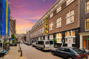 una strada cittadina con auto parcheggiate accanto a un edificio di Hans Brinker Hostel Amsterdam ad Amsterdam