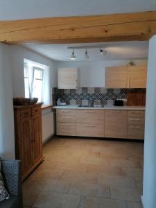 a large kitchen with wooden cabinets and a tile floor at Ferienhaus Wastl 91355 Hiltpoltstein,Möchs 11 in Hiltpoltstein