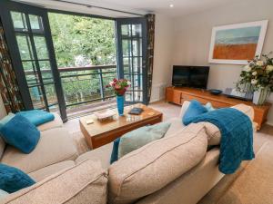 a living room with a couch and a television at The Moorings in Lostwithiel