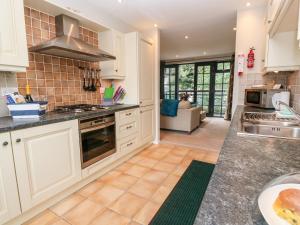 a kitchen with white cabinets and a stove top oven at The Moorings in Lostwithiel