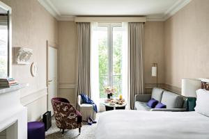 a hotel room with a bed and a couch at Sofitel Le Scribe Paris Opera in Paris +197 photos