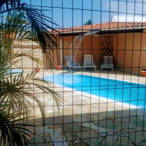 une villa avec une piscine et une maison dans l'établissement Suítes Praia Martin de Sa, à Caraguatatuba