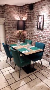 tavolo e sedie in una stanza con muro di mattoni di Les Remparts a Montreuil-sur-Mer