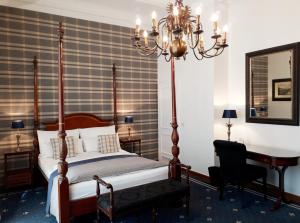a bedroom with a bed and a desk and a mirror at Boutique Hotel Windsor - The Charming City Hotels in Düsseldorf