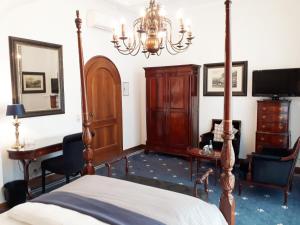 1 dormitorio con cama, escritorio y lámpara de araña en Hotel Windsor, en Düsseldorf